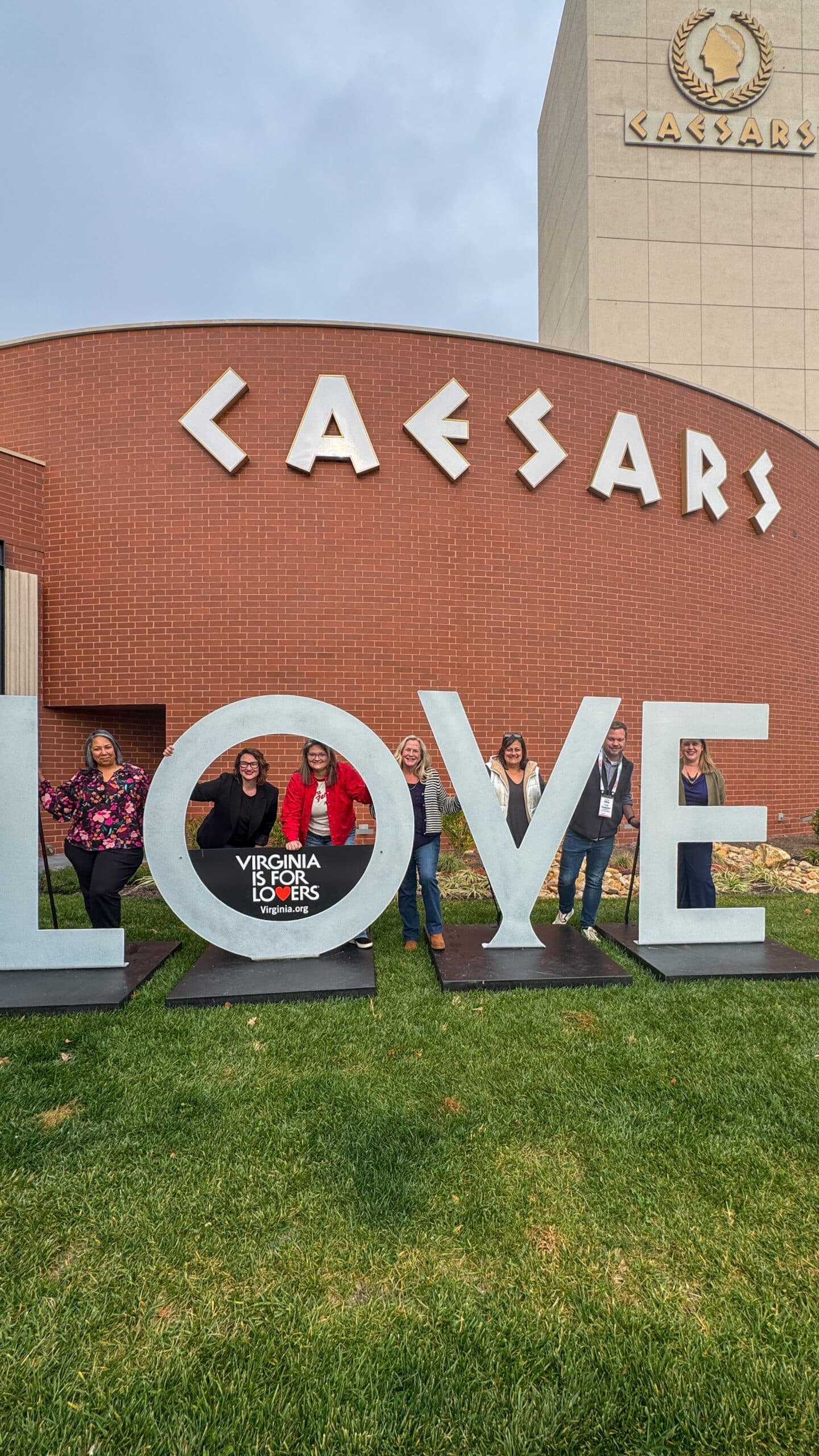 The Letterpress Communications team and partners stand behind the LOVE sign at the 2025 VA-1 Governor’s Tourism Summit in Danville, VA.