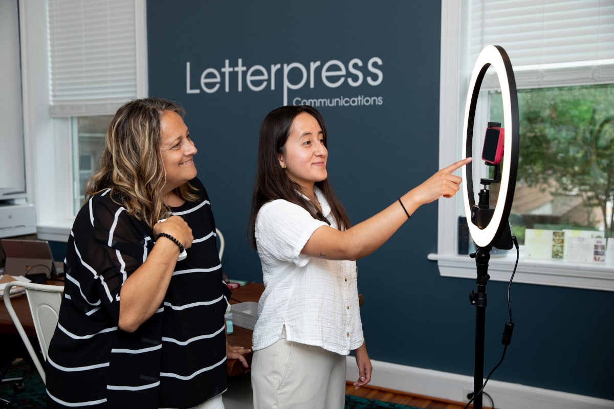 Letterpress Communications intern Maria Chavez-Alonso and Director of Community Success Jennifer Kinne work with videography equipment at the Letterpress office in Farmville.